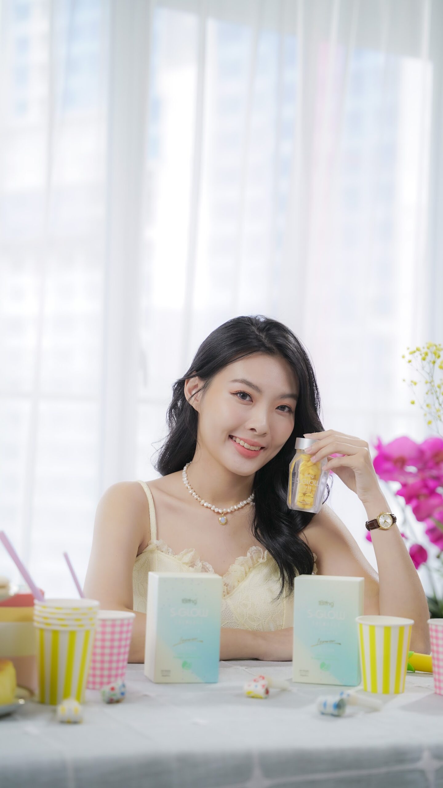 Model tersenyum memegang produk S-GLOW
